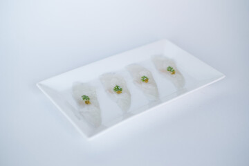 Sashimi on white plate on white background. Isolated on white. Japanese restaurant. Japanese traditional food. Raw white fish. Photo for the menu