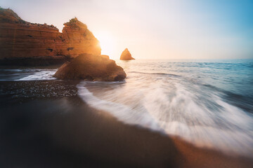 Wall Mural - Sea Waves at Praia Dona Ana Beach with beautiful Rock formations at sunrise - Long Exposure shot - Lagos, Algarve, Portugal