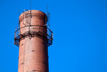 Red Brick Old Chimney Of A Factory On Blue Sky Background