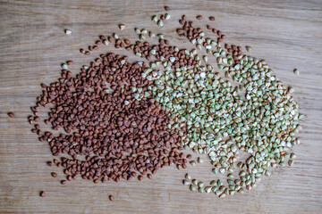  Green fresh buckwheat and toasted brown buckwheat on a white oak board. Autumn foods close-up for a healthy diet.