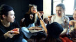Group of diverse schoolkids eat pizza and laugh 