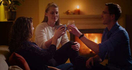 Poster - A meeting between two female Caucasian and a Caucasian male toasting at night in front of a fireplace