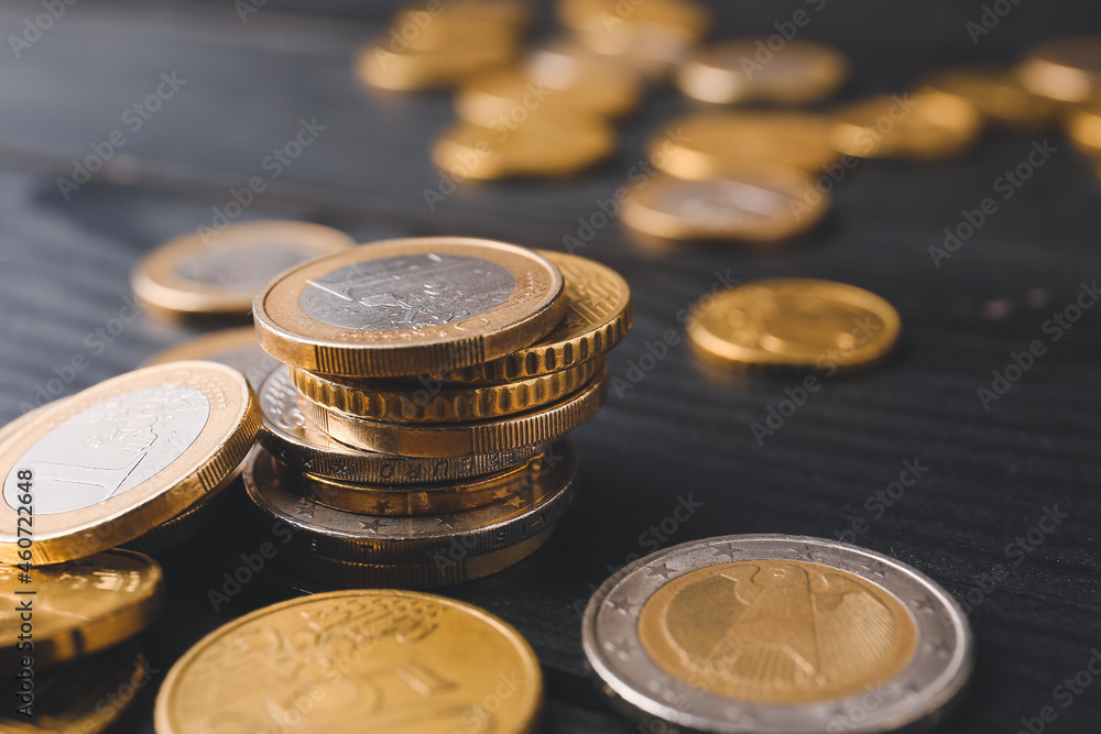 Golden coins on dark wooden background