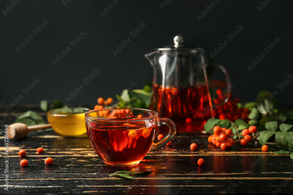 Cup of hot rowan tea on wooden table