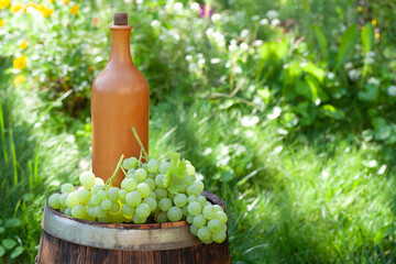 Wall Mural - Grapes and wine bottle on wine barrel