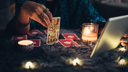 Fortune teller showing tarot cards online. Online tarot cards with tablet or smartphone. Astrologists and horoscope online concept.