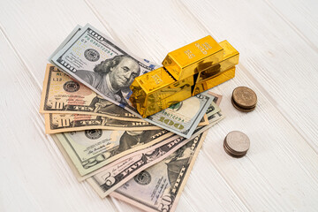 dollar bills coins shiny gold bars lie on a new wooden table