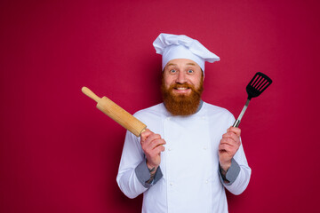 Wall Mural - happy chef with beard and red apron chef holds wooden rolling pin
