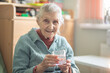 An elderly woman holds a glass glass with water in her hand, health care, grandmother drinks water for health, retirees at home during quarantine.
