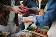 © Halfpoint - Close up of mans hands buying organic vegetables outdoors at local farmers market.