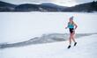 © Halfpoint - Active senior woman in swimsuit running outdoors in winter, cold therapy concept.