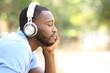 © PheelingsMedia - Profile of black man listening to music in a park