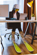 woman in ski equipment working on laptop in office