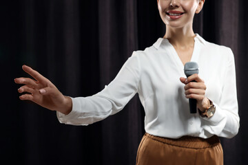 Wall Mural - Motivational speaker with microphone performing on stage, closeup