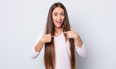 Wall Mural - hispanic pretty woman feeling happy, surprised and proud, pointing to self with an excited, amazed look