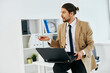 © SHOTPRIME STUDIO - man in beige jacket holding a phone laptop office technologies