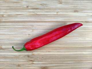 Red hot chili peppers on old wooden table surface texture background