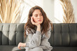© cenchild - bored woman sitting on couch. girl sitting on couch in bad mood and prop up head with hand