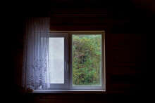 A Window With A Curtain And A Pigeon On The Windowsill In A New Wooden House On The Attic Floor