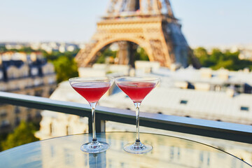 Two Cosmopolitan cocktails in traditional martini glasses with view to the Eiffel tower, Paris, France
