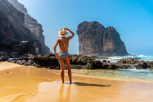 A Young Tourist With A Hat In The Roque Del Moro Of The Cofete Beach Of The Jandia Natural Park, Barlovento, South Of Fuerteventura, Canary Islands. Spain