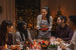 © Syda Productions - holidays and celebration concept - multiethnic group of happy friends having christmas dinner at home