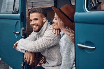 Poster - Beautiful young loving couple bonding and smiling while spending time in their minivan