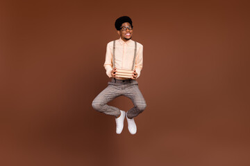 Wall Mural - Photo of a-student geek guy jump hold pile textbook materials wear suspenders sneakers isolated brown color background