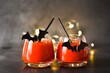 © Iryna80 - Halloween Cocktail. Food Concept. Glasses with Black Bats and light garland on a gray table. Halloween drink. Selective focus