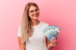 © Asier - Young russian woman holding bills isolated on pink background happy, smiling and cheerful.