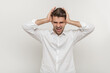 Photo of nervous screaming young man with headache standing isolated over white background wall. Man in stress concept. noisy neighbors concept