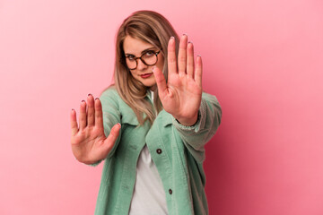 Young russian woman isolated on pink background being shocked due to an imminent danger