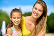 © zinkevych - A beautiful young woman in a yellow swimming suit and her daughter on a beach