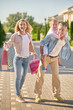 © zinkevych - Man holding daughter on back and woman with purchases