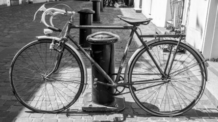 Sticker - Grayscale shot of a vintage French-style rusty bike on a paved road