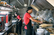 © pressmaster - Gloved man in uniform putting fast food on electric stove for baking or frying