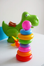 Toy Rings And Green Dinosaur On White Shelf