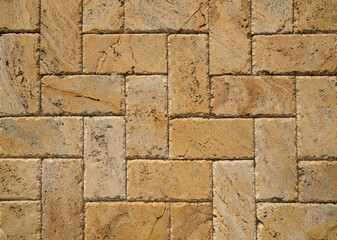 Wall Mural - Yellow brown stone pavers background. Neutral texture of a flat brick wall close-up.        