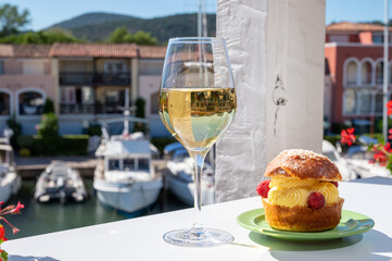 Tarte tropezienne or La Tarte de Saint-Tropez - dessert pastry consisting of filled brioche with cream and fresh berries.and glass of white wine