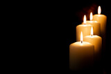 Burning candles on dark background. front view.