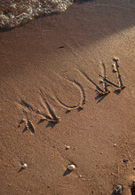 NOW Sign In Wet Sand 