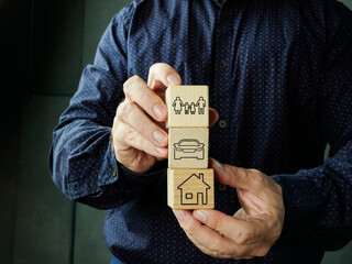 Poster - Comprehensive insurance coverage. Man holds cubes with home, car and family.