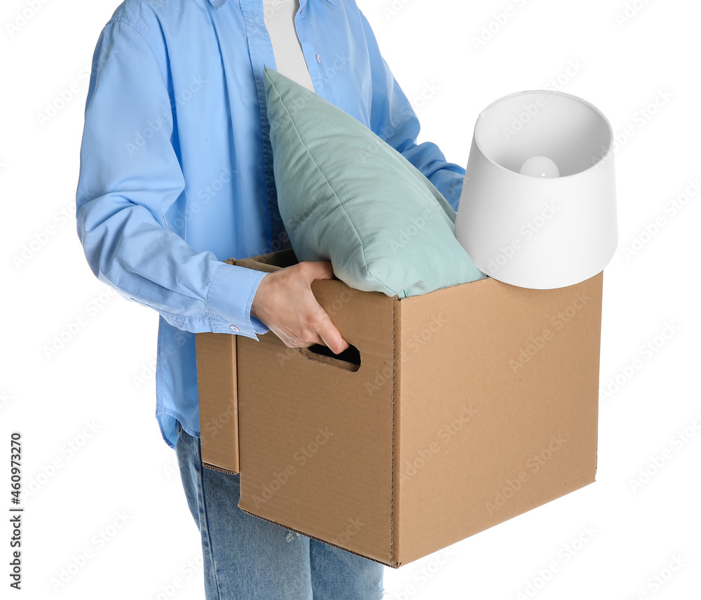 Woman holding wardrobe box with lamp and pillow on white background