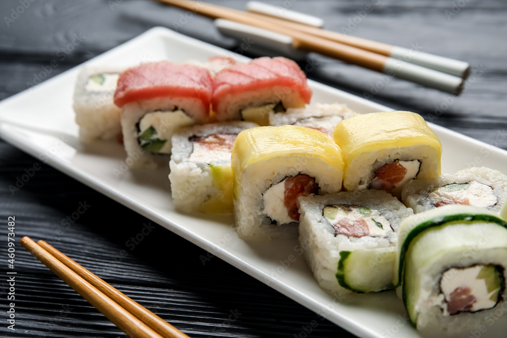 Set of delicious sushi rolls on grey wooden table
