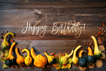 Wall Mural - autumn pumpkin decoration, text happy birthday, wooden background
