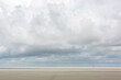 © Westend61 - Large clouds over vast empty beach