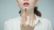 © Chris Tefme - Photo of woman with rainbow manicure beckoning finger