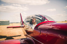 Smiling Mature Woman Piloting Airplane During Sunny Day