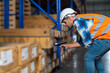 Warehouse worker checking the packages using barcode reader in a large warehouse distribution center. Caucasian male inspects cargo inventory.