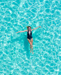 © Timelapse4K - Top view aerial of a seductive sexy model in black swimwear is enjoying relax in turquoise sea summer weekend. Tropical background with empty space.